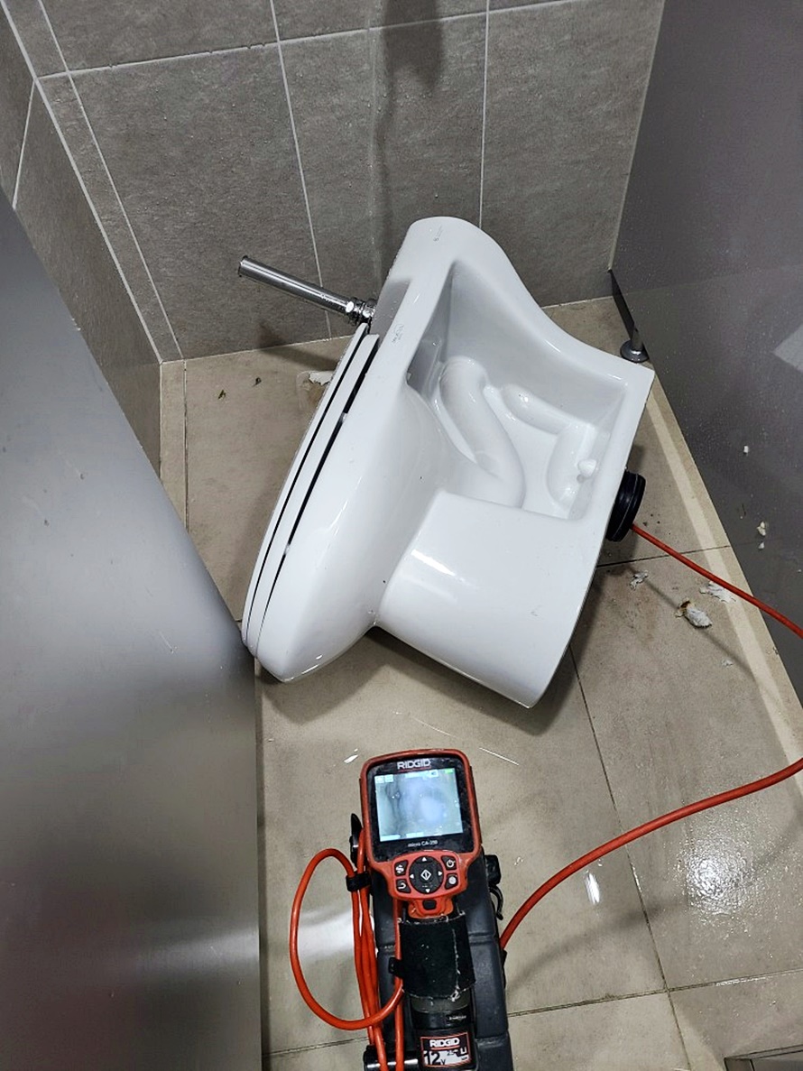 변기가 탈거된 상태에서 다른 각도로 장비가 연결된 모습