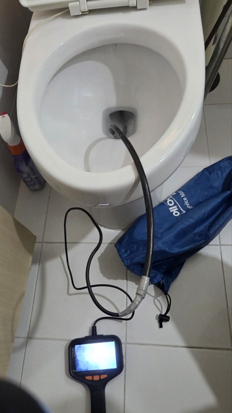변기에 내시경 카메라 선을 넣어 점검하는 모습