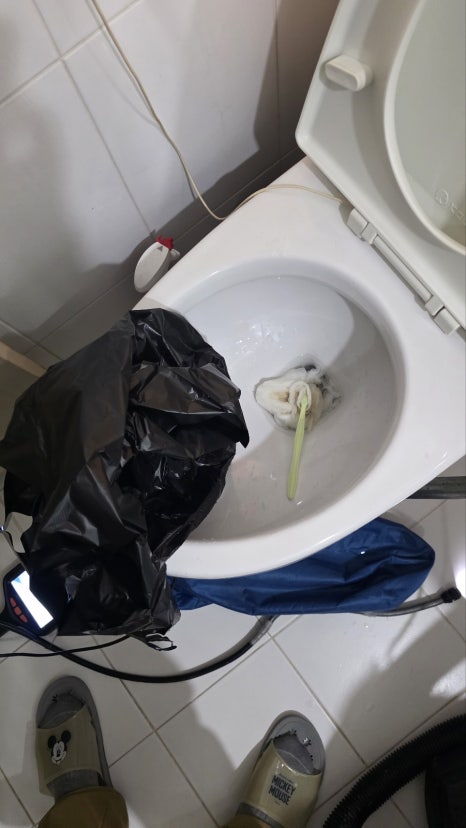 변기에 검은 봉투를 씌운 채 석션 작업을 하는 모습