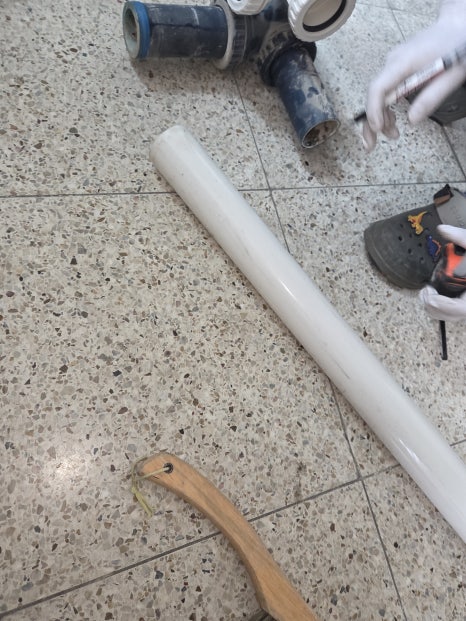 바닥에 놓인 흰색 PVC 배관과 이음쇠 조각